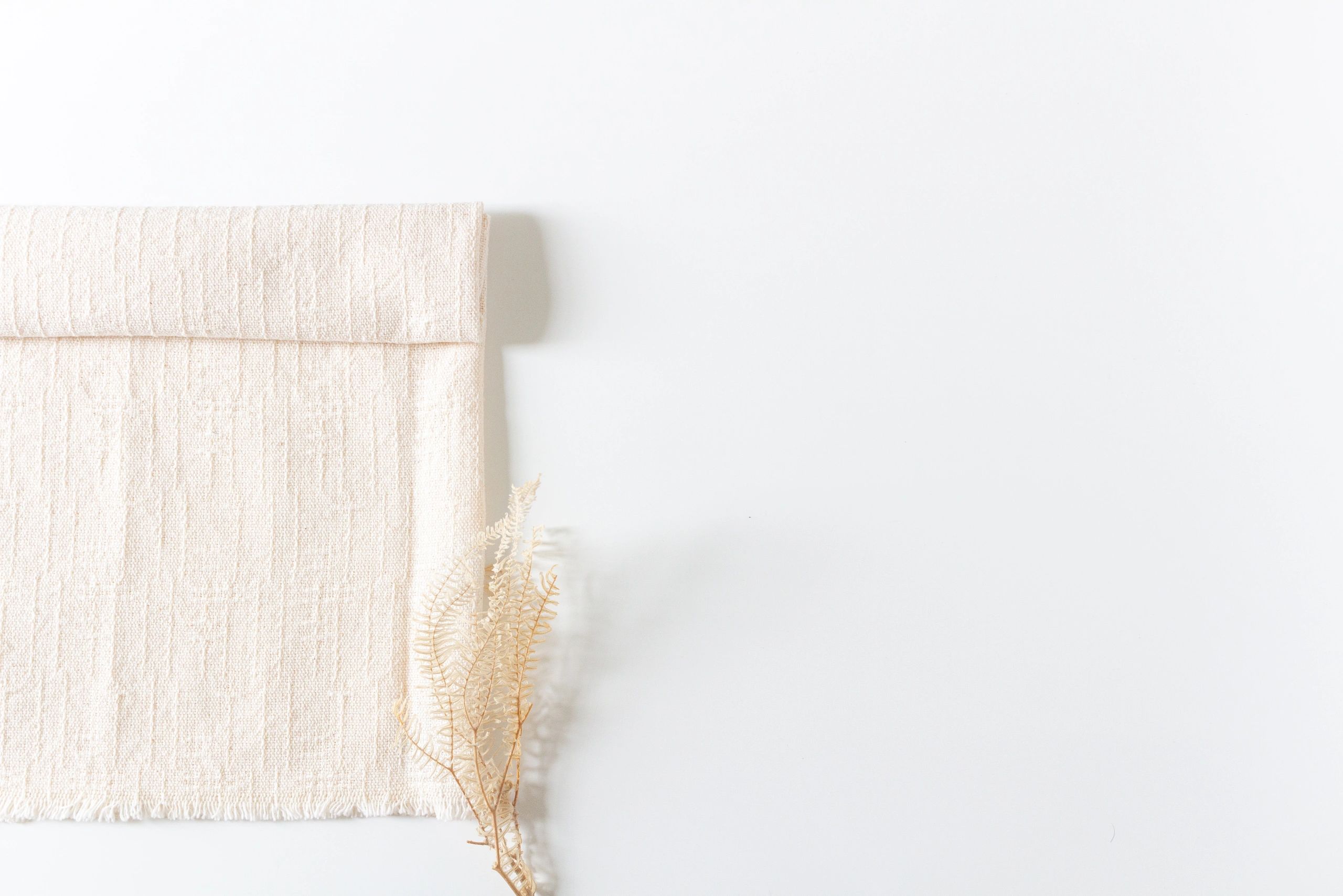 Sewing tools and fabric arranged on a white background